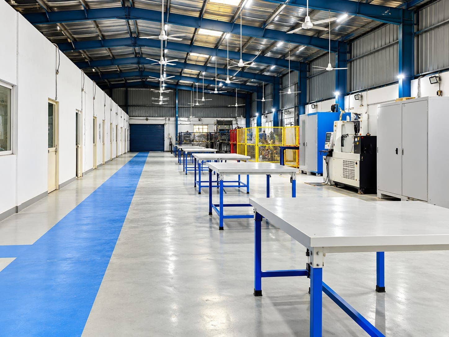 Bright industrial workshop aisle with blue epoxy walkway and work benches